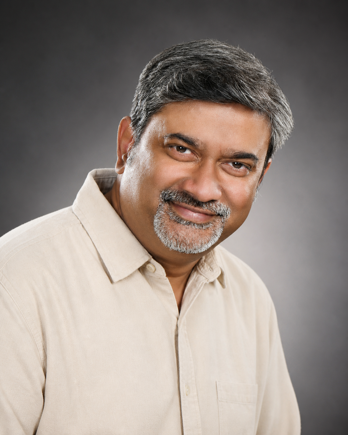 Stanly smiling in a studio portrait